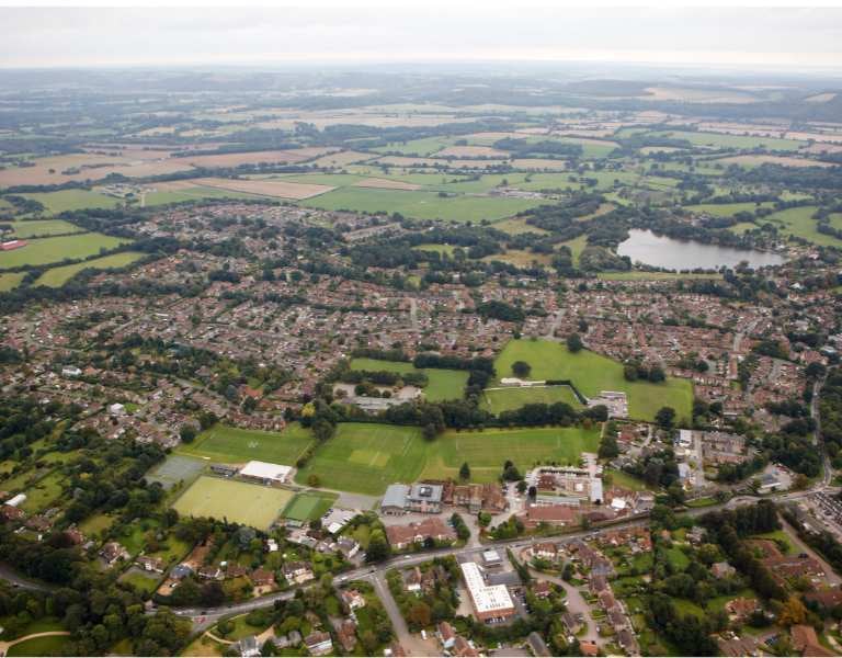 Aerial view of Churcher's College in Petersfield, featuring sports fields, tennis courts, and the surrounding residential areas.