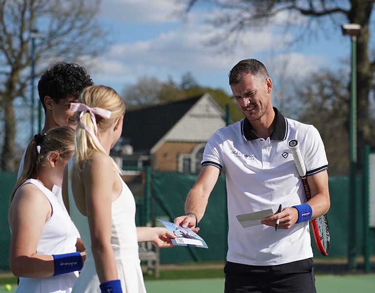 Jamie Murray hands out leaflets to junior tennis students at Churcher's School tennis courts.