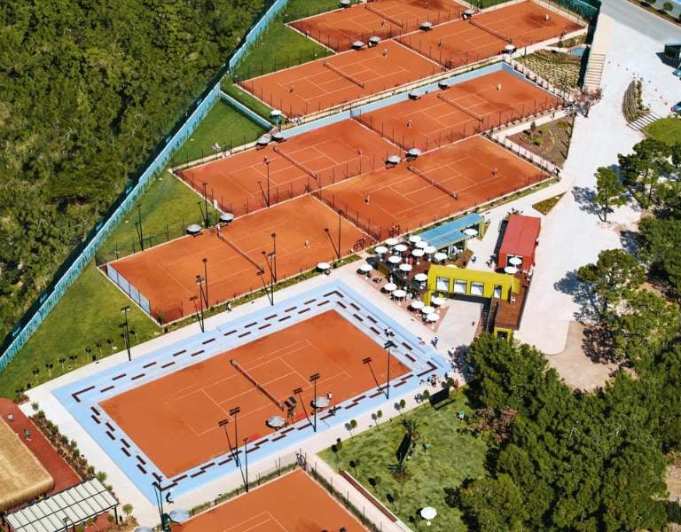 Aerial view of Corendon Gallery's clay tennis courts and adjacent leisure area with seating.