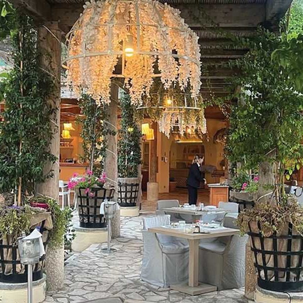 Al fresco dining area at Daphnila Bay with white flower decorations and greenery.