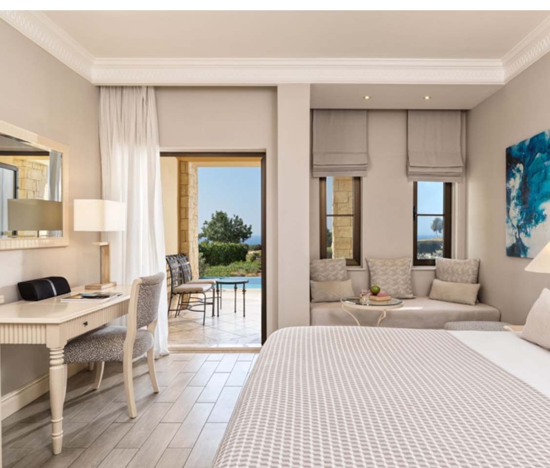 Deluxe double room with elegant decor, a private pool terrace, and views of a golf course and sea in the background.
