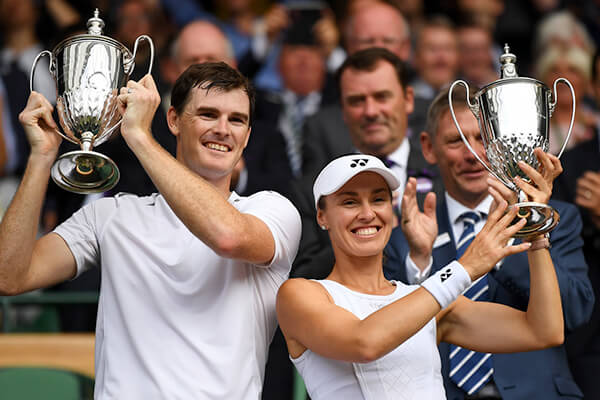 Jamie Murray and Martina Hingis celebrate with trophies after winning the Wimbledon Mixed Doubles title.