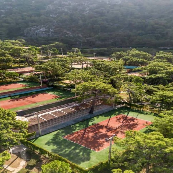 Aerial view of Liberty Lykia Family resort tennis courts surrounded by greenery and pine trees.