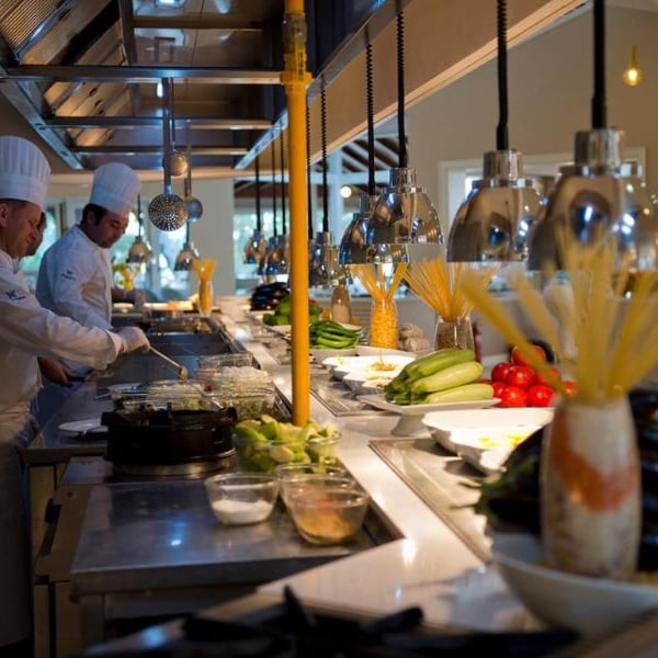 Two chefs preparing meals with fresh ingredients in a modern kitchen at Liberty Lykia.