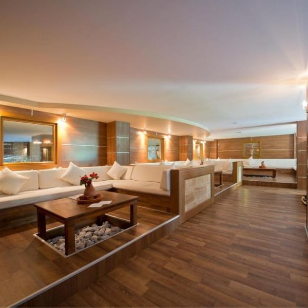 Lounge area at Liberty Lykia with cream sofas, wooden flooring and tables, creating a warm and inviting atmosphere.