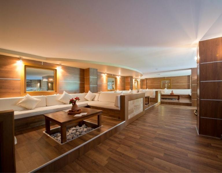 Lounge area at Liberty Lykia with cream sofas, wooden flooring and tables, creating a warm and inviting atmosphere.