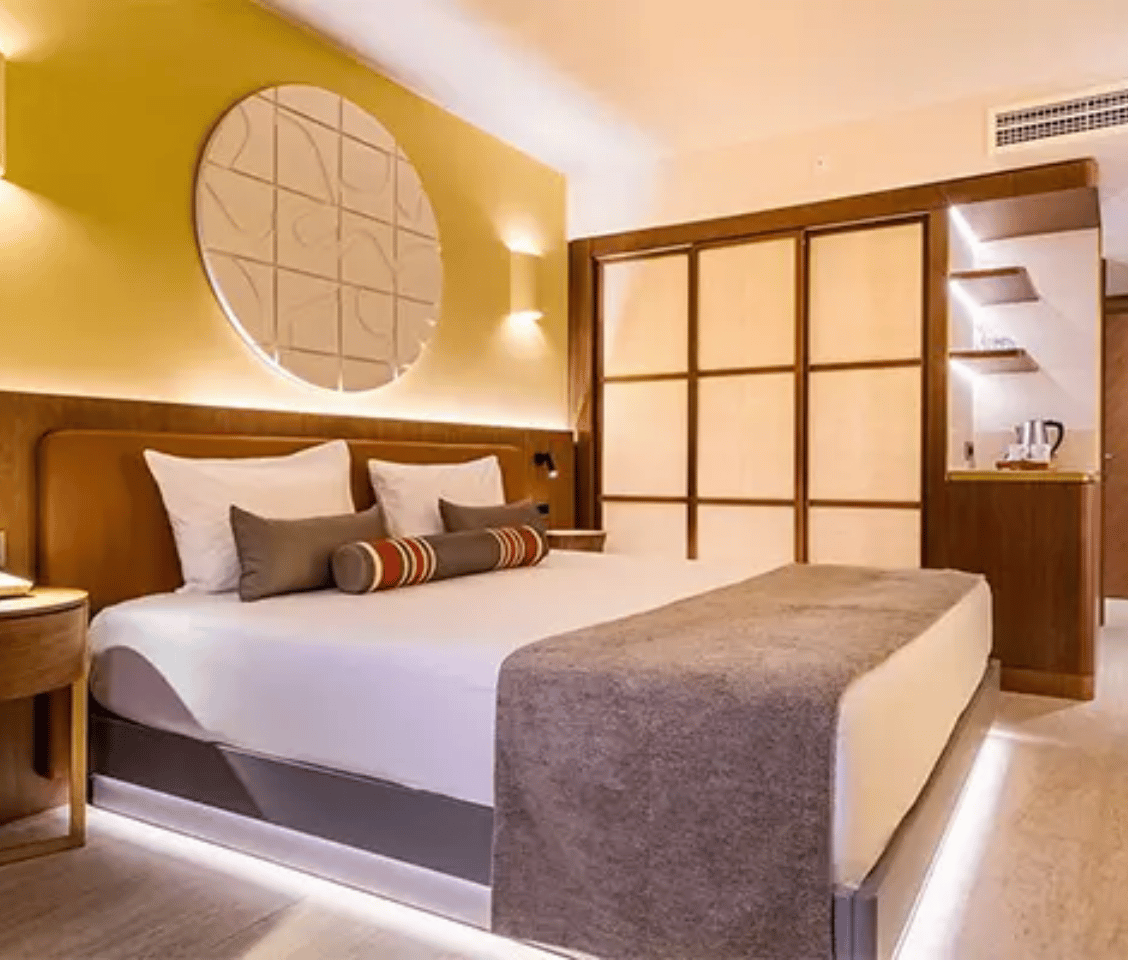 Liberty Village Deluxe Standard Sea View room with a king-size bed, modern decor, ambient lighting, and a coffee station.