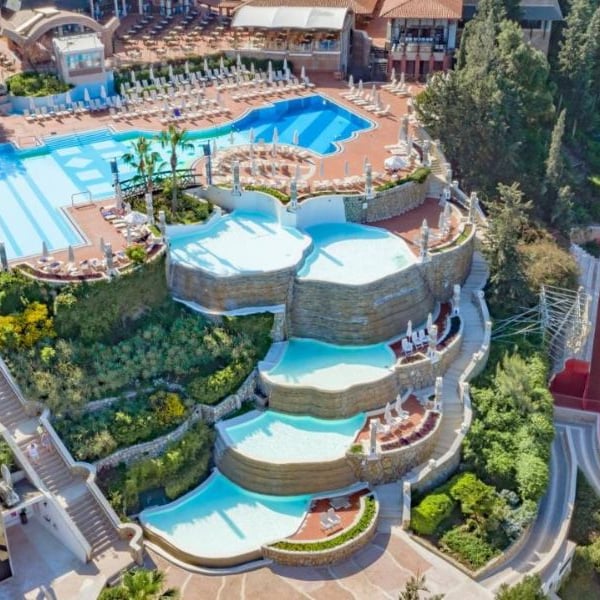 Aerial view of tiered infinity pools at Liberty Village, surrounded by greenery and leisure facilities.
