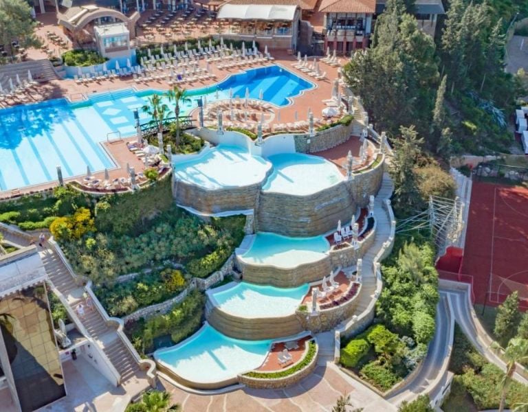 Aerial view of tiered infinity pools at Liberty Village, surrounded by greenery and leisure facilities.