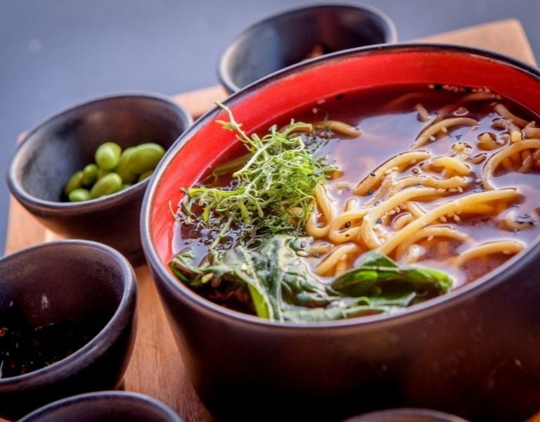 Asian noodle soup with broth, noodles, fresh greens, and edamame beans from Lyttos Mare.