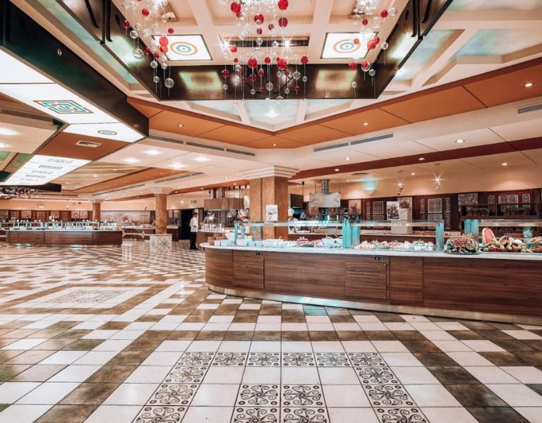 Expansive buffet area at Royal Mare Gallery with modern wooden counters, a tiled floor, and decorative ceiling lights.