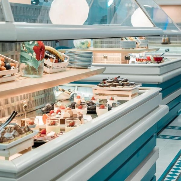 Royal Mare Gallery buffet with fresh fruits in baskets and trays of assorted desserts like pastries and cakes.