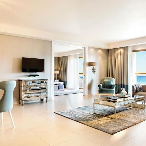 Luxurious hotel room at Sani Beach with modern furniture and large windows showing an ocean view.