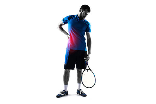 Silhouetted tennis player holding back in pain, illustrating common tennis injuries.