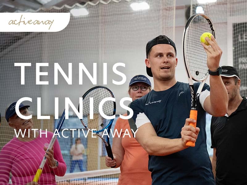 Active Away tennis clinic with a coach demonstrating a technique to attentive participants holding racquets.