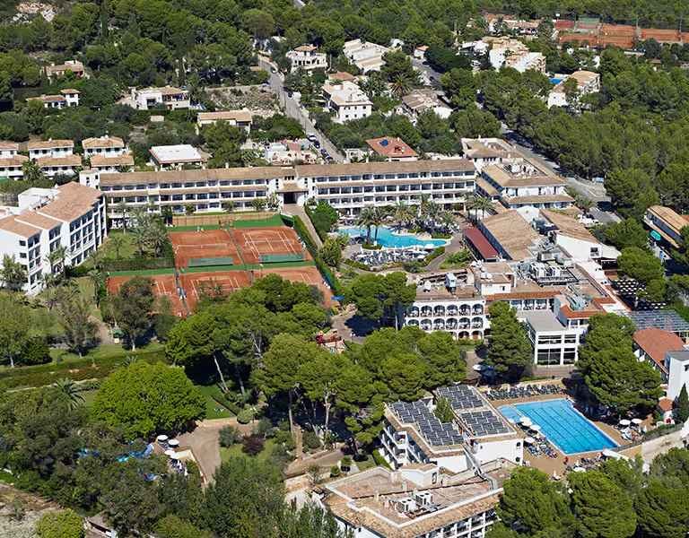 Aerial view of Beach Club School Tours hotel, highlighting tennis courts, swimming pools, and surrounding greenery.