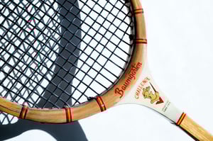Vintage Baumgarten Challenge wooden tennis racket with red and white accents against a white background.