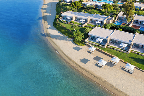 Aerial view of Olivia Resort's beachside villas with private pools and direct beach access, featuring sun loungers and umbrellas on the sandy shore.