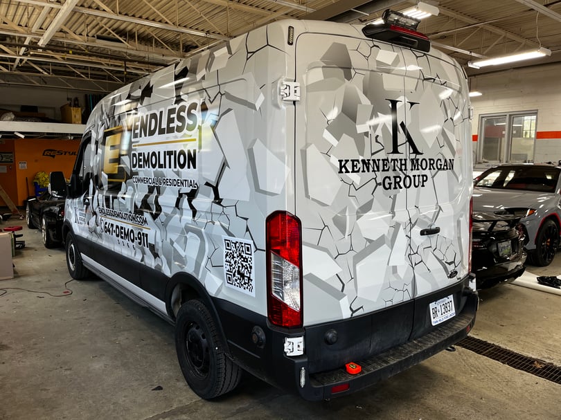 Full printed demolition company wrap across a high-roof cargo van