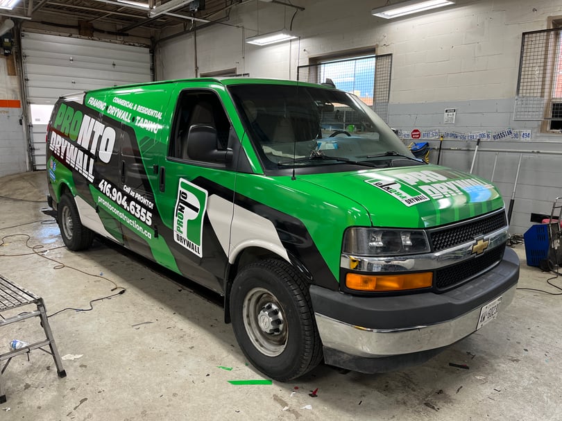 Green, black, and white commercial wrap across a service van front and side
