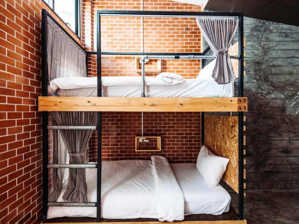 A typical bunkbed at a hostel with a red brick wall