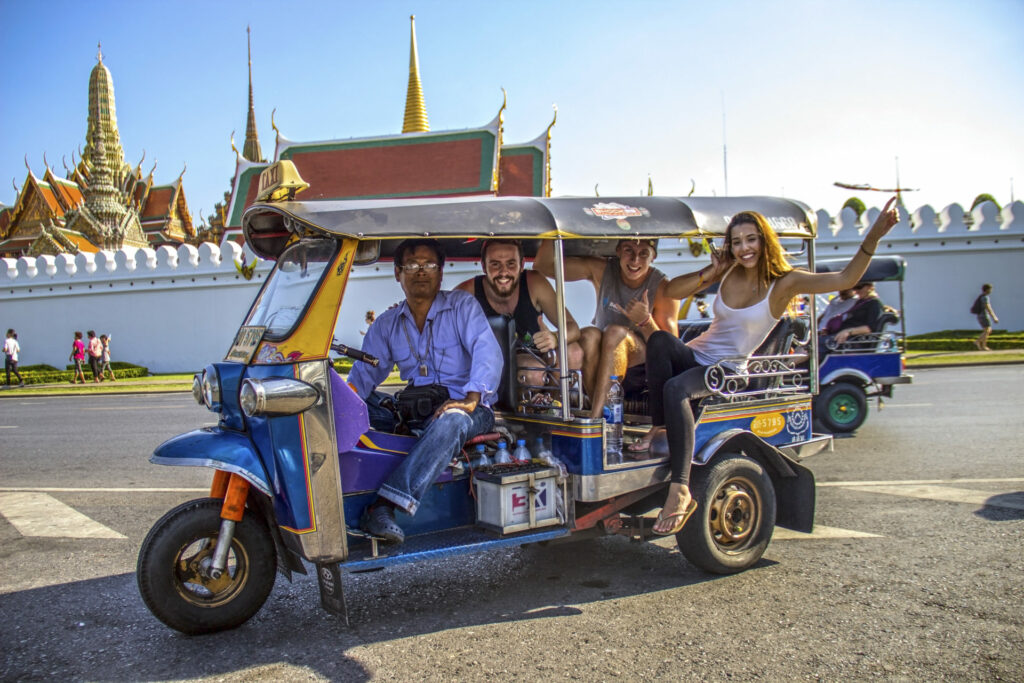 5 people smiling in a blue and yellow Tuk-tuk