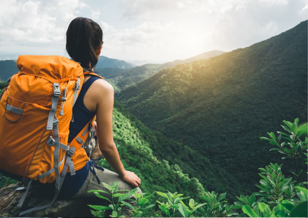 A girl with an orange backpack looking over the mesmerizing nature of Thailand