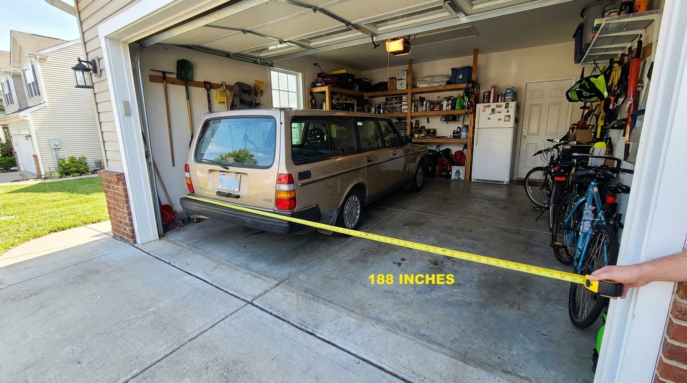 A car parked in a garage with a measuring tape along its bumper