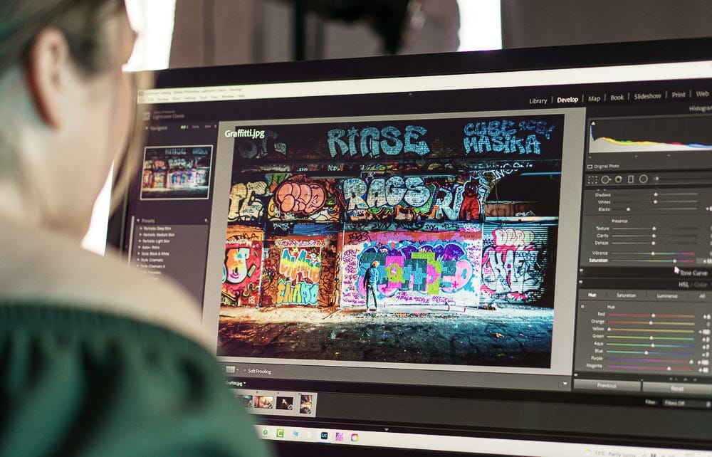 a lady sat at a computer editing photos in Lightroom