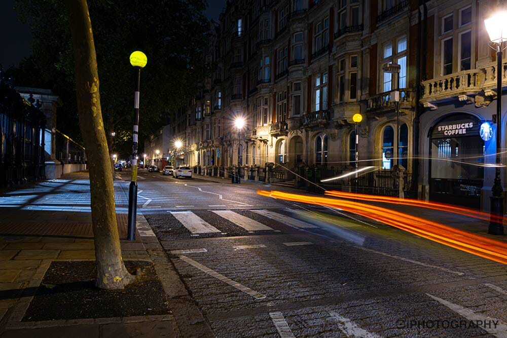 trails of car tail lights going along a road