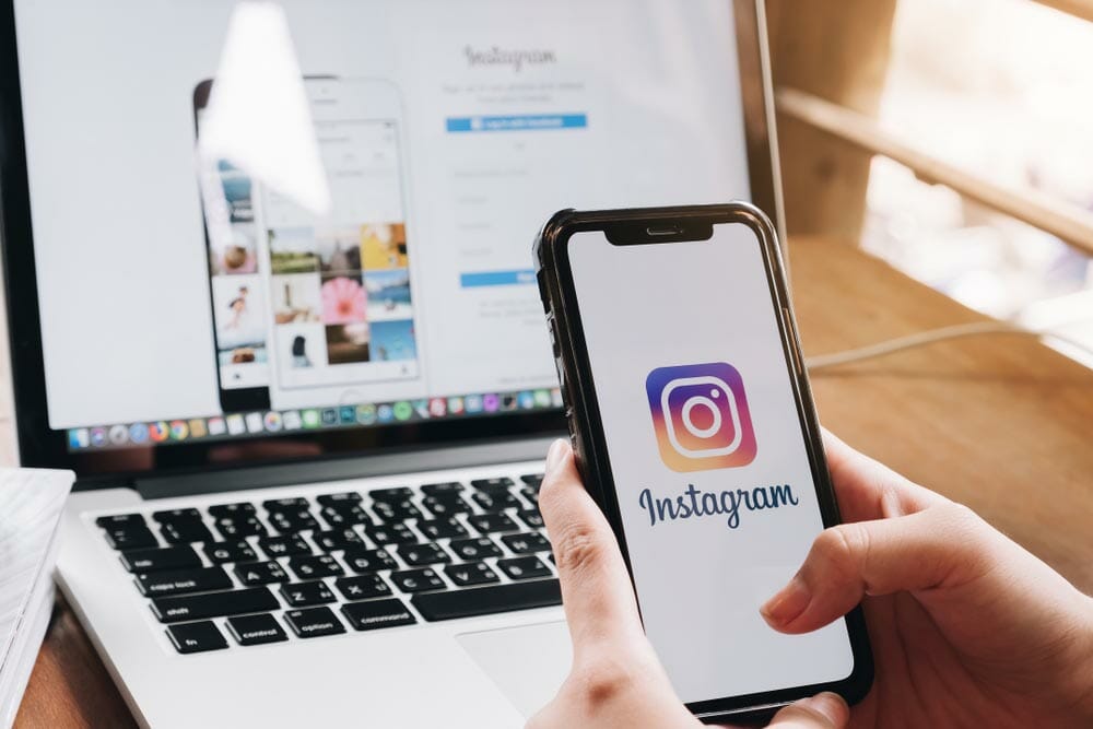 A woman holds Apple iPhone X with Instagram application on the screen at cafe. Instagram is a photo-sharing app for smartphones.