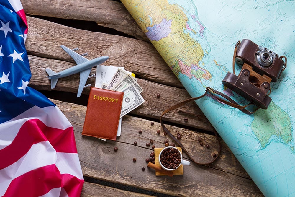 Brown passport and US flag. Photo camera on a map. Spend your vacation abroad. Visa to USA is opened.