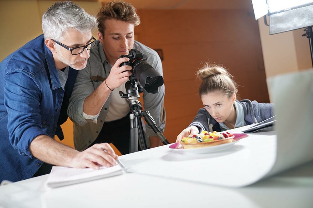 Photographer with apprentice in photo studio