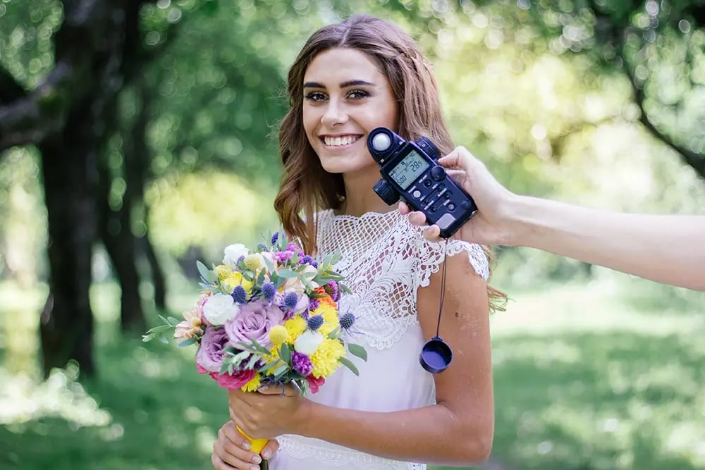 Hand Holding a Light Meter in front of a Bride