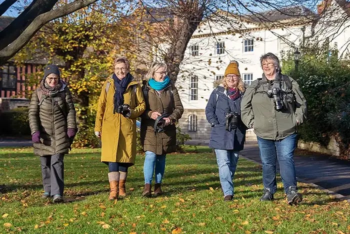Five iPhotography Members standing on a lawn in front of a Georgian building on a sunny autumn day, cameras in hand — a real Photo Walk.