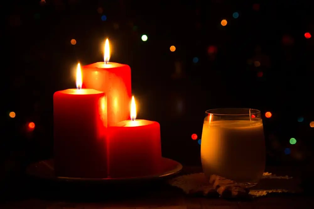 Three candles lit in the dark next to a glass of milk. Copyright Robert Paterson (iPhotography Student)