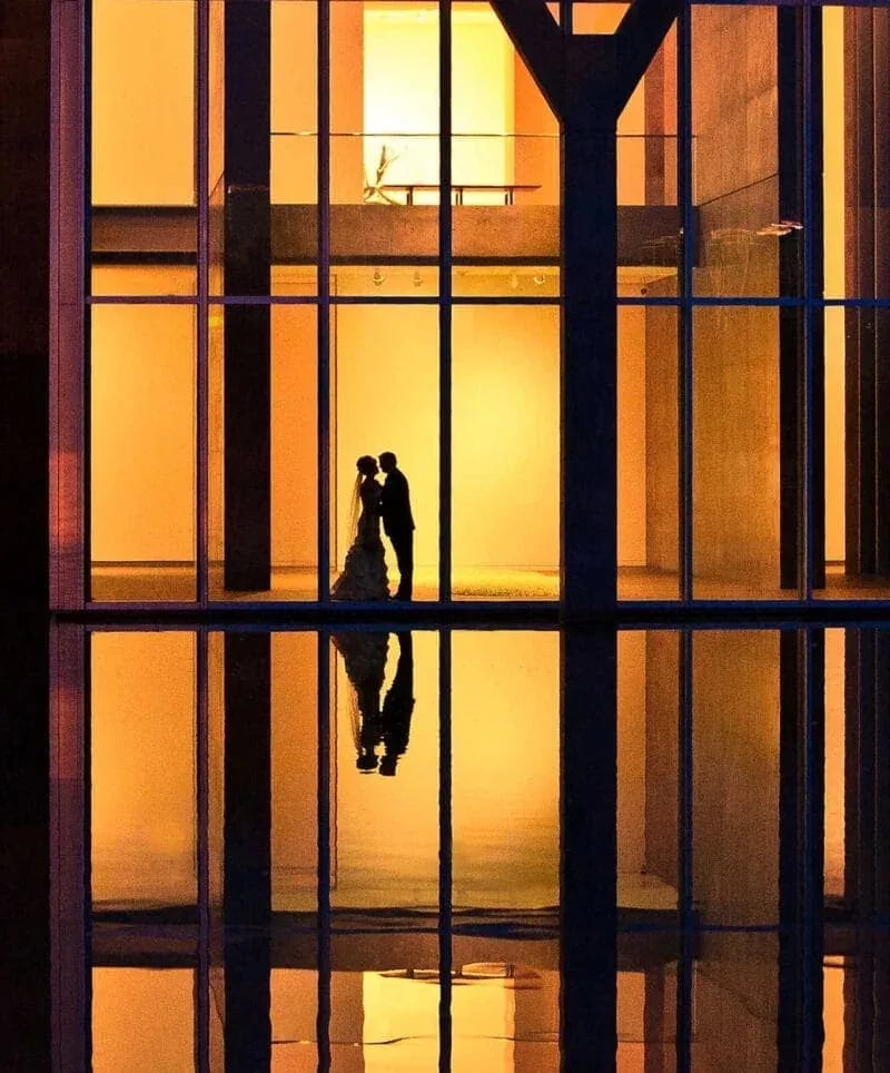 Dramatic Idaho wedding photography silhouette of bride and groom in a church great room with reflection and warm backlighting