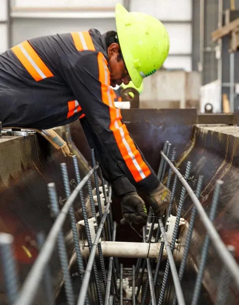 Construction worker assembling rebar grid inside concrete formwork—captured for Idaho industrial photography in Boise and the Treasure Valley.