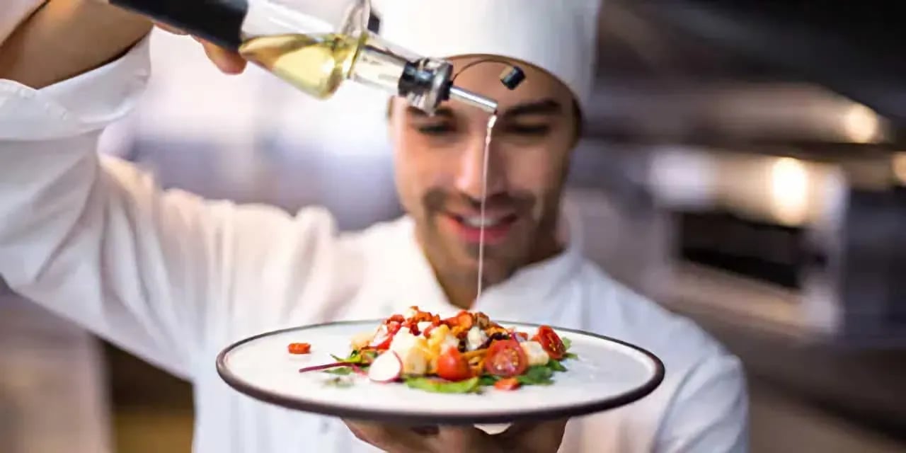 Chef pouring olive oil over a fresh salad with cherry tomatoes, radishes, and greens—captured for Idaho food photography in Boise and the Treasure Valley.