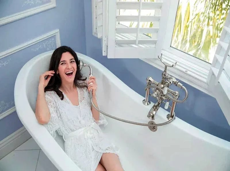Bride laughing in a white lace robe while preparing for her wedding, captured by Idaho Photography Studios during a joyful pre-ceremony moment.