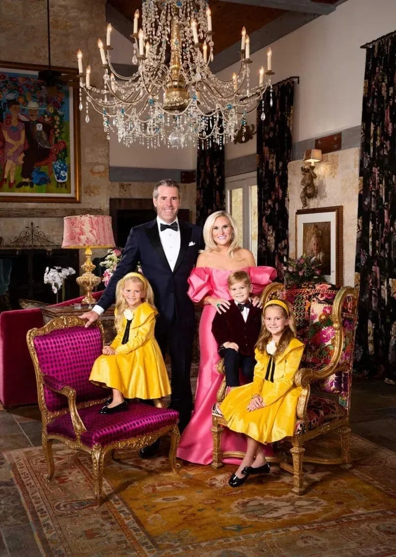 Formal family portrait in opulent interior with crystal chandelier, gold-trimmed chairs, and vibrant attire, featuring two adults and three children, part of Idaho Photography Studios’ Masters Family Portraits series.
