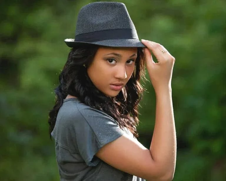 High School Senior Portrait: Gal with Hat Against Trees