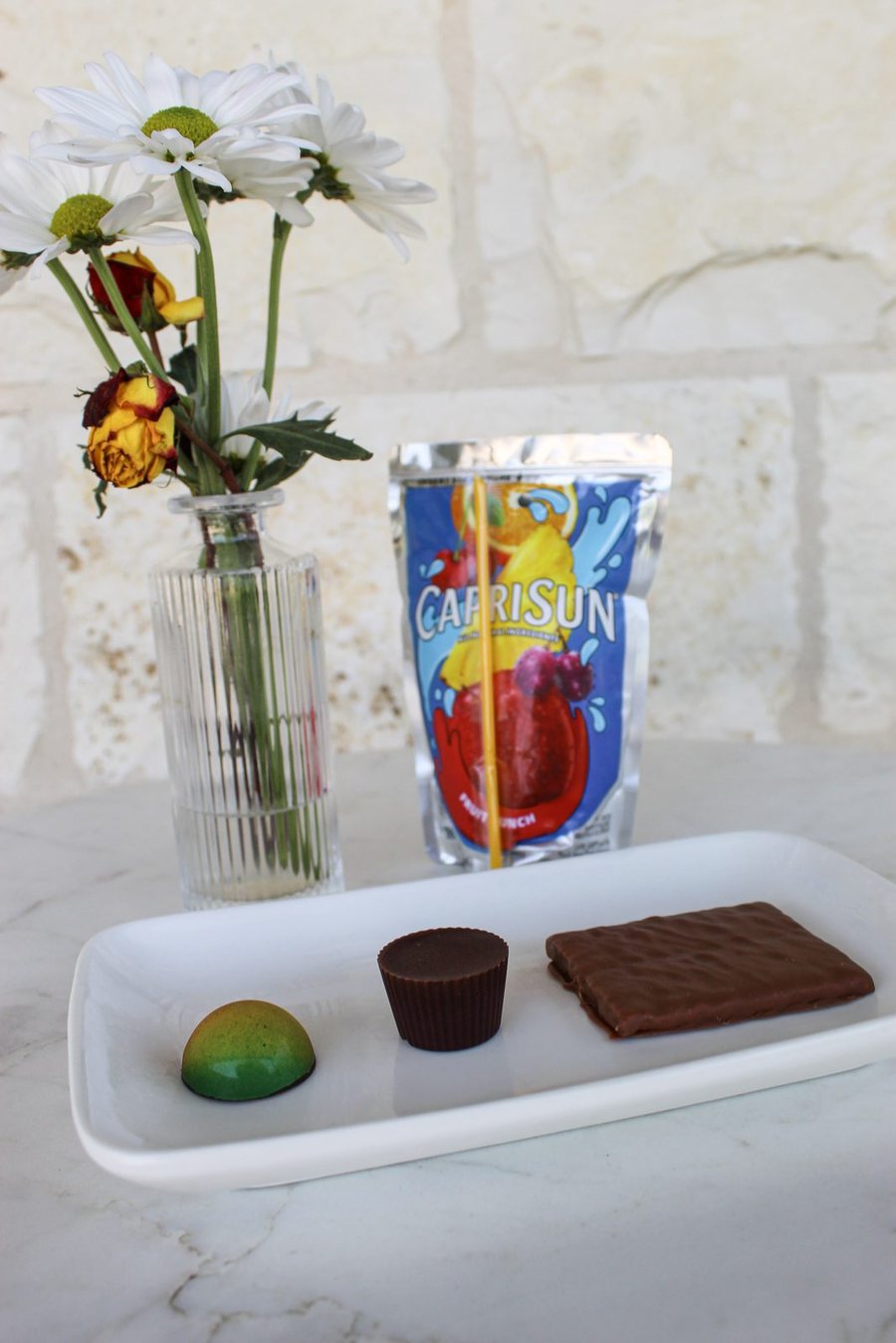 A white tray with three kid-friendly chocolates and a Capri Sun pouch