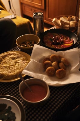 a table with tapas dishes like tortillas patata, coquetta, tomatoes and figs