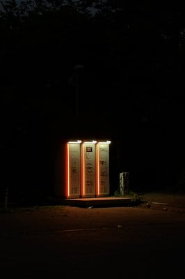 a group of white metal structure with vertical orange lights as fluorescent over light at night