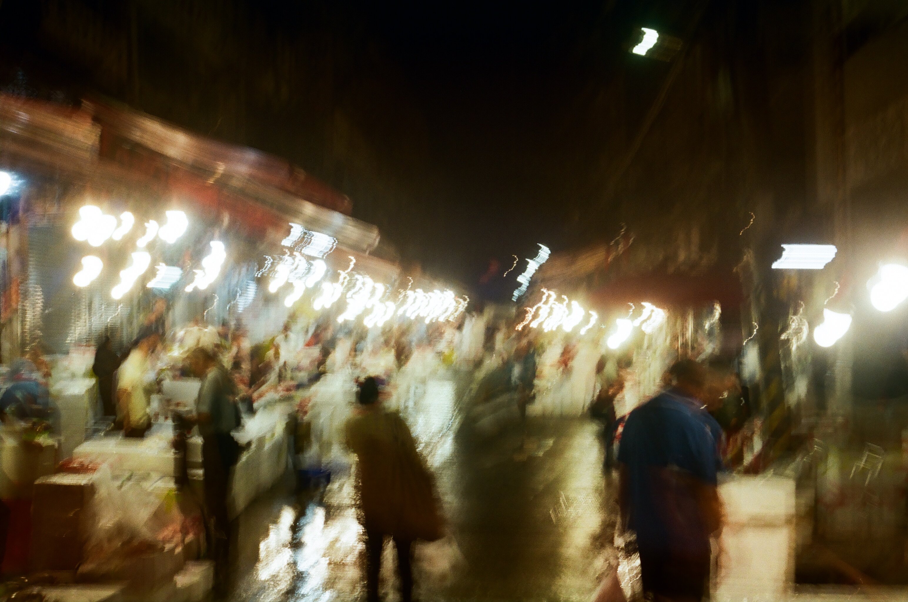 a blurry image of people walking in a fishmarket