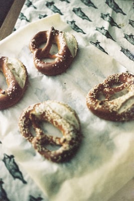 pretzels on a parchment paper on a table cloth of black and white pigs flying