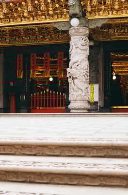 The front of a temple, a stone pillar with dragon cravings on it