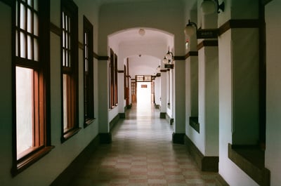 a hallway with white walls and a tile floor