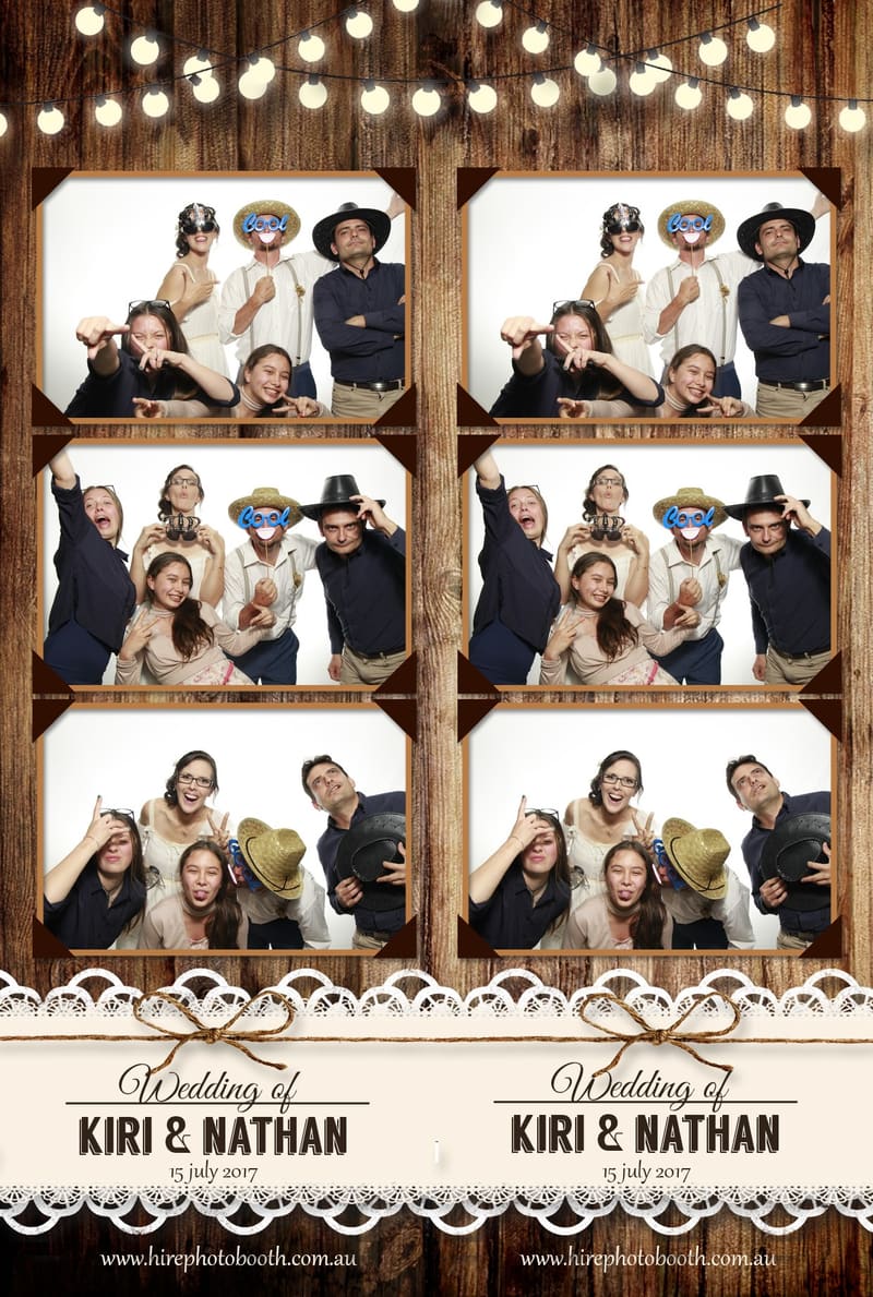 Group of guests posing with props in a photo booth at a wedding.